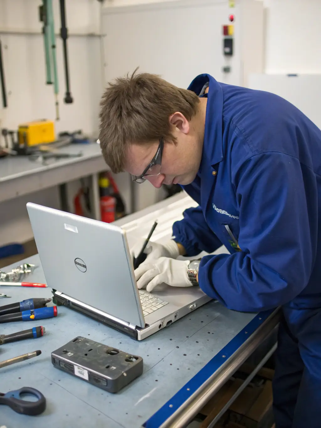 A technician in a cleanroom environment carefully disassembling a laptop, showcasing AtlasCare IT's meticulous approach to device repair.
